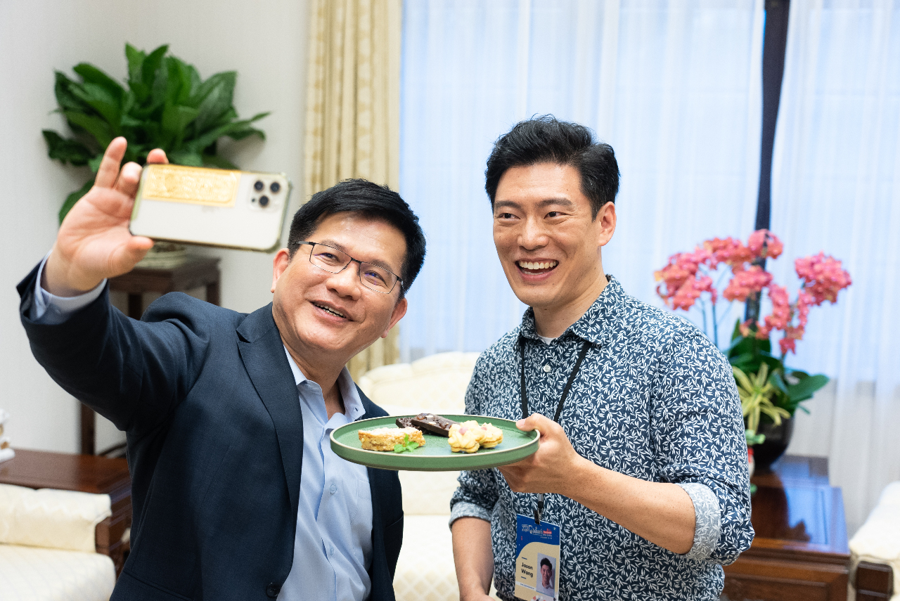 Tổng Thư ký Phủ Tổng thống Lâm Giai Long (ảnh trái) cùng chụp ảnh với đầu bếp lừng danh Jason Wang (ảnh phải), cùng tham gia trong đợt tuyên truyền chương trình “Trọ một đêm tại Phủ Tổng thống” năm 2023. (ảnh: Tổng hội Văn hóa cung cấp)